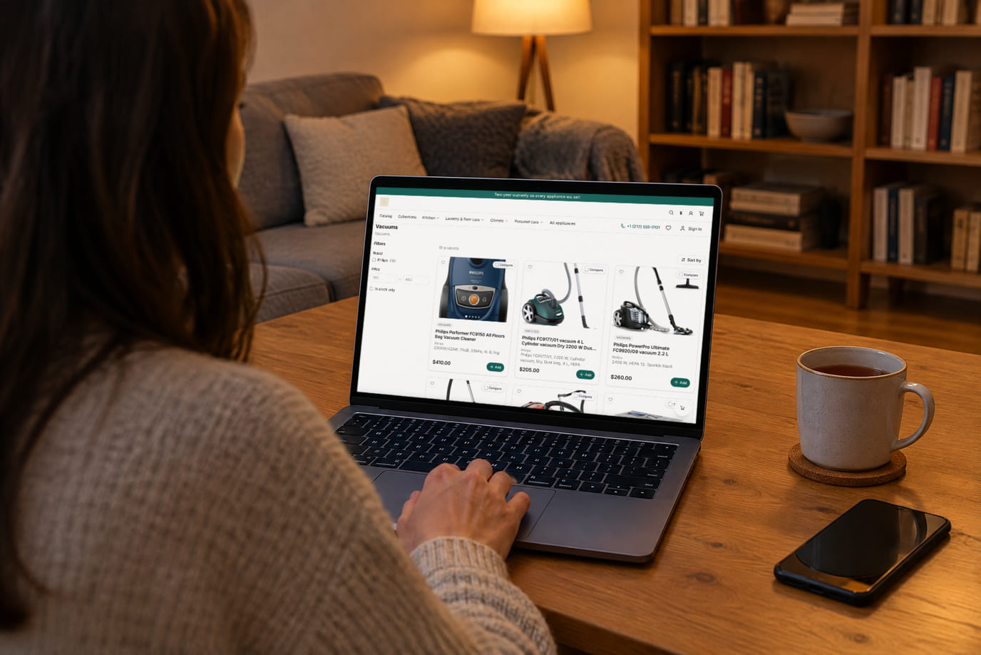 A shopper at home on the sofa browses an online store on a laptop